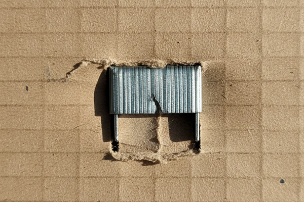 foreign material like a metal staple embedded in corrugated board